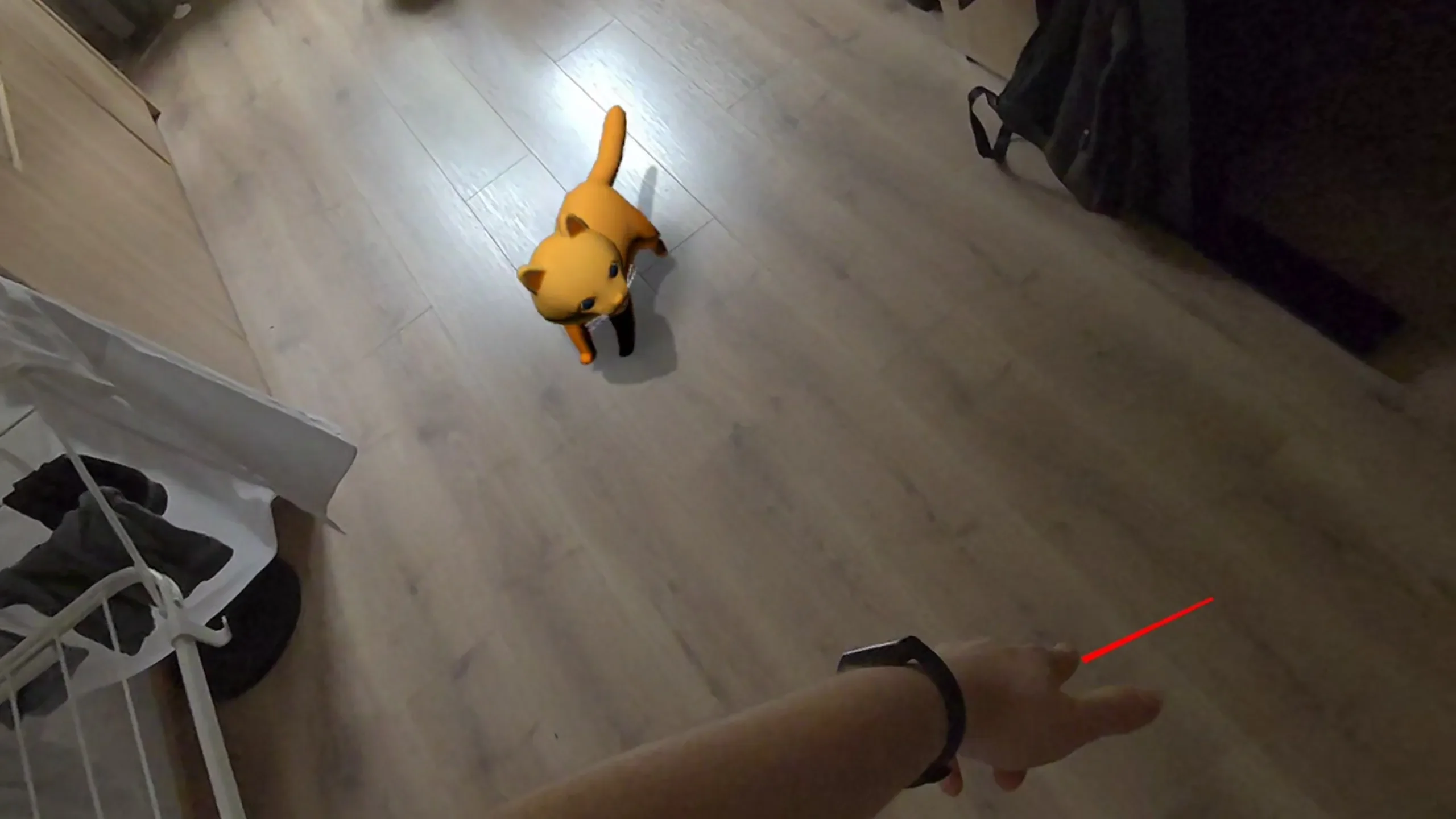Player using a hand-held laser pointer while Tobby follows the dot in a real room